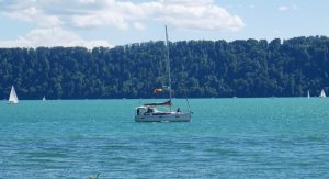 SBF Binnen – Segelboot auf einem ruhigen Binnengewässer als Symbol für die SBF Binnen Prüfung