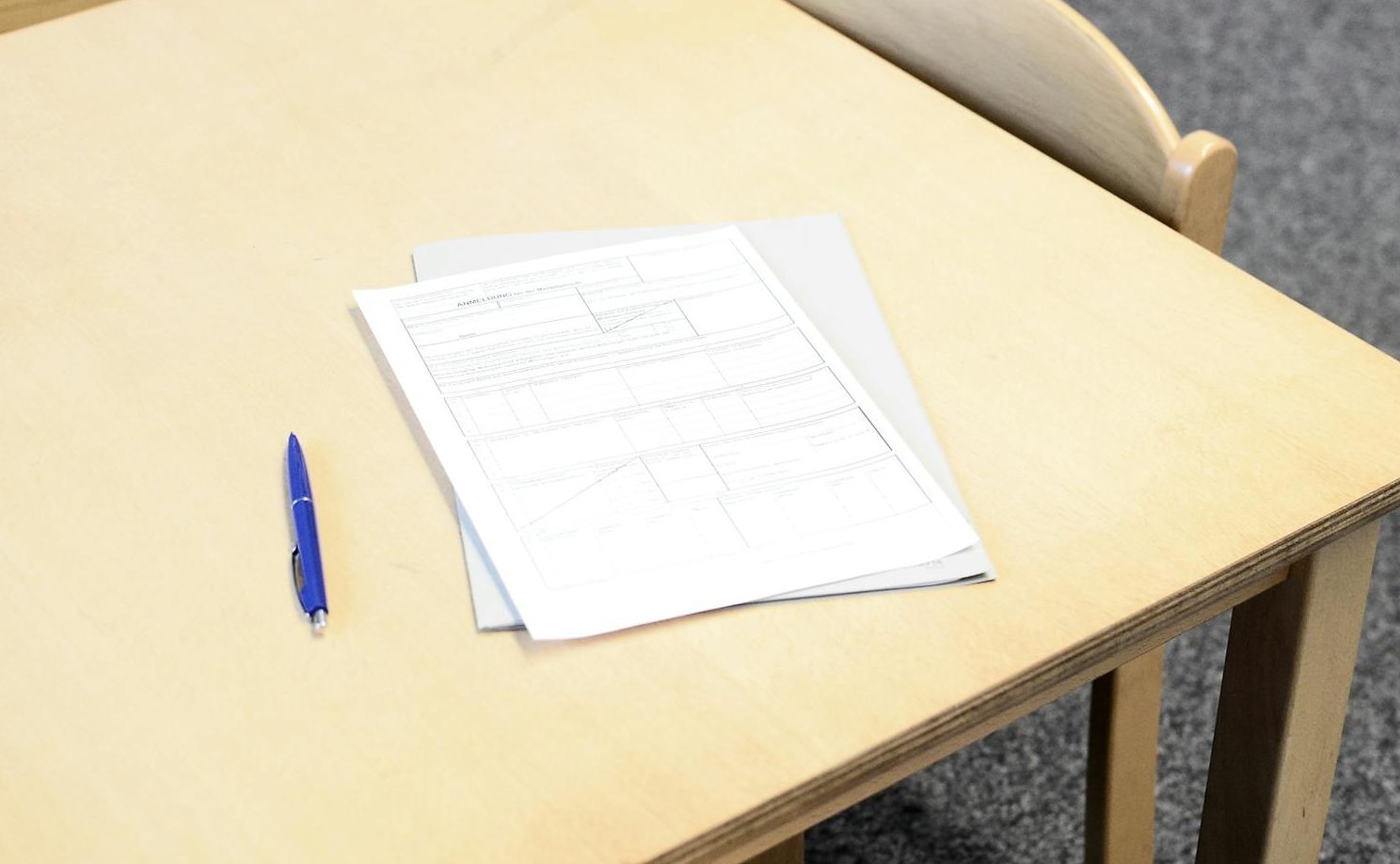 Ausgefüllter Zulassungsantrag für die Bootsführerschein-Prüfung mit Stift auf Holztisch – Unterlagen rechtzeitig innerhalb der 7-Tage-Frist einreichen.