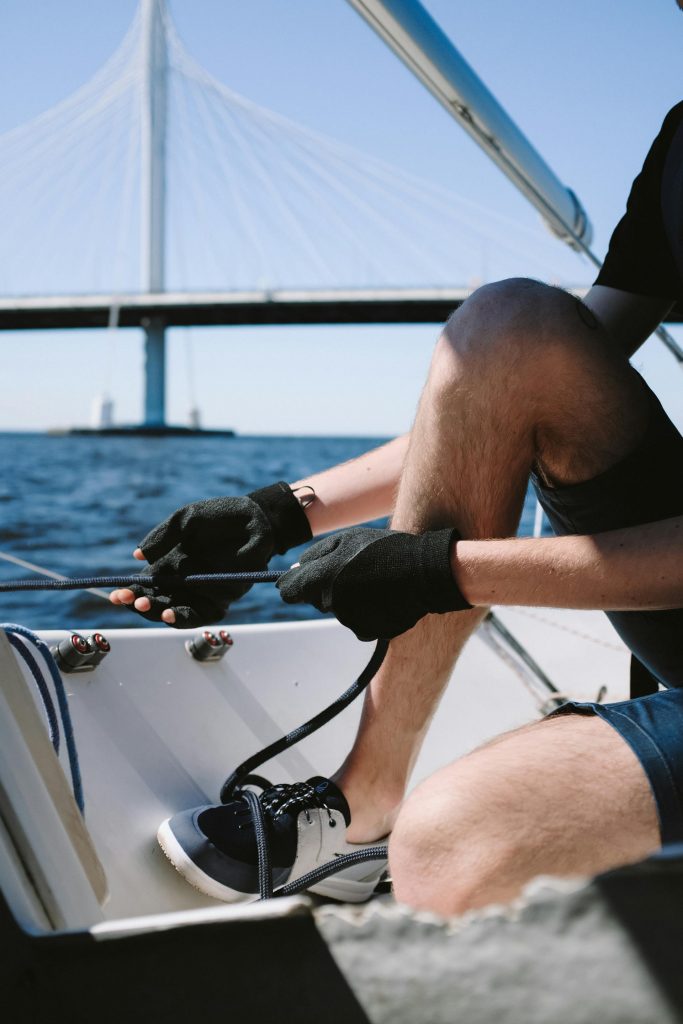 Teilnehmer übt an der Winsch das Führen einer Leine auf einem Segelboot – Praxisprüfung SBF.