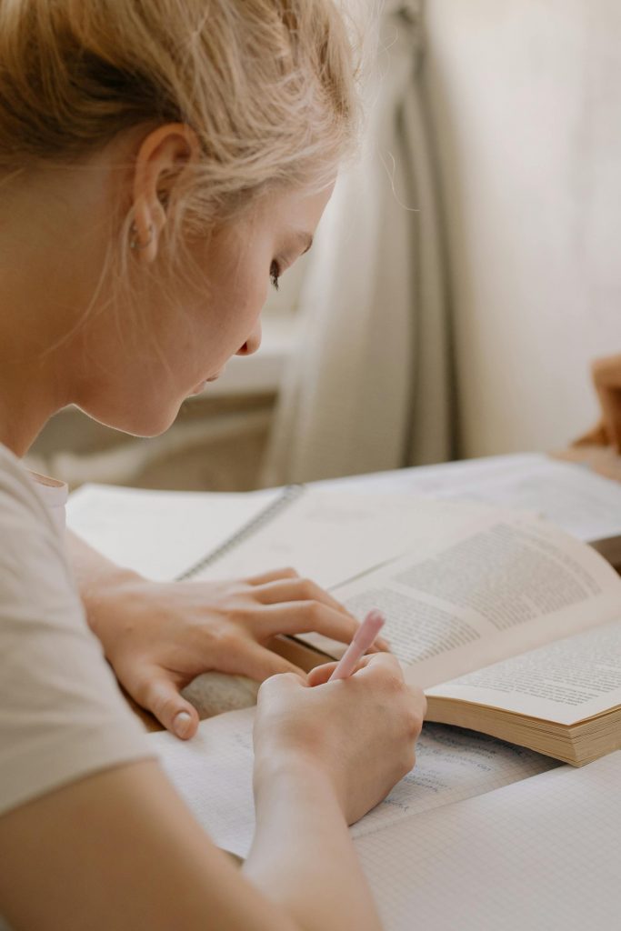 Junge Frau lernt mit Buch und Notizen für die Theorieprüfung zum Bootsführerschein SBF See & Binnen.