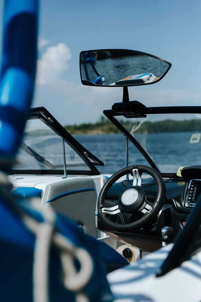 Blick ins Cockpit eines Motorbootes mit Steuerrad – Praxis für den SBF See.