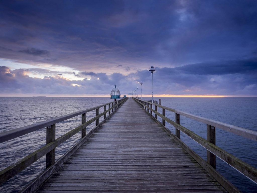 Seebrücke an der Ostsee bei Sonnenuntergang – Symbol für Bootsfahrten mit deutschem Sportbootführerschein im Ausland.